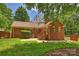 Brick home's backyard featuring a patio, stairs, and well-maintained lawn at 3901 Kitley Pl, Charlotte, NC 28210