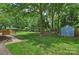 Spacious backyard with mature trees, storage shed, and swing set at 3901 Kitley Pl, Charlotte, NC 28210