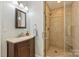 Bathroom with a glass shower, earth-tone tile, updated vanity, and plenty of space at 3901 Kitley Pl, Charlotte, NC 28210