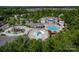 Aerial view of a community pool area, featuring multiple pools, a splash pad, and ample seating for residents at 4040 Deep River Way, Waxhaw, NC 28173