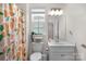Bright bathroom with vanity, a decorative shower curtain, and a window at 4040 Deep River Way, Waxhaw, NC 28173