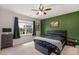 Sunlit bedroom with a ceiling fan, accent wall, and exterior view at 4040 Deep River Way, Waxhaw, NC 28173