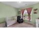 Cozy bedroom featuring a large window, baby crib, and plush recliner at 4040 Deep River Way, Waxhaw, NC 28173