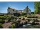 Picturesque view of a historic mill house with a water wheel and a serene pond, surrounded by lush landscaping at 4040 Deep River Way, Waxhaw, NC 28173