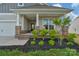 Inviting front porch with brick accents, stone columns, and rocking chairs at 4040 Deep River Way, Waxhaw, NC 28173