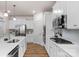 Well-equipped kitchen showcasing stainless steel appliances, white cabinets, and wood flooring at 4040 Deep River Way, Waxhaw, NC 28173