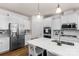 Modern kitchen featuring stainless steel refrigerator, white cabinetry, and a spacious island at 4040 Deep River Way, Waxhaw, NC 28173