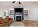Inviting living room with fireplace, built-in shelving, and mounted TV at 4040 Deep River Way, Waxhaw, NC 28173