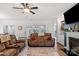 Cozy living room features a ceiling fan, reclining sofa, and fireplace with built-in shelving at 4040 Deep River Way, Waxhaw, NC 28173