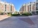 An inviting exterior view with brick buildings, landscaping, and a brick paved area at 4625 Piedmont Row Dr # 410, Charlotte, NC 28210
