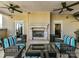 Inviting outdoor lounge with a stone fireplace, ceiling fans, and comfortable seating area at 4625 Piedmont Row Dr # 410, Charlotte, NC 28210