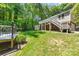 Expansive backyard with mature trees, deck, storage shed, and lush green lawn at 4700 Hickory Grove Rd, Mount Holly, NC 28120