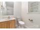 Compact bathroom featuring a toilet, sink, and walk-in shower at 4700 Hickory Grove Rd, Mount Holly, NC 28120