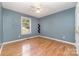 Bedroom with light blue walls, hardwood floors, and a window at 4700 Hickory Grove Rd, Mount Holly, NC 28120