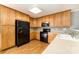 The kitchen features wooden cabinets, black appliances, and hardwood floors at 4700 Hickory Grove Rd, Mount Holly, NC 28120