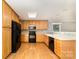 The kitchen has black appliances, wooden cabinets, a mosaic backsplash, and hardwood floors at 4700 Hickory Grove Rd, Mount Holly, NC 28120