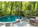 Backyard pool surrounded by lush greenery and featuring a wooden deck with seating at 4700 Hickory Grove Rd, Mount Holly, NC 28120