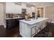 Large kitchen island with bar seating complements modern white cabinets, quartz countertops, and black accents at 5059 Valita Rd, York, SC 29745