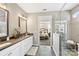A stylish bathroom showcasing a double vanity, tiled shower, and view into the primary bedroom at 5075 Valita Rd, York, SC 29745