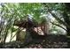 View of elevated wooden deck in the backyard with stairs leading to the ground, surrounded by trees and lush greenery at 5127 Murrayhill Rd, Charlotte, NC 28210