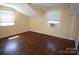 Bedroom featuring hardwood floors, two windows and a window air conditioner at 5127 Murrayhill Rd, Charlotte, NC 28210