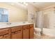 Well-lit bathroom with double sink vanity, wood cabinets, and a shower-tub combination at 516 Tribune Dr, Charlotte, NC 28214