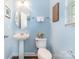 Powder room featuring a pedestal sink, toilet, decorative mirror, and natural light at 516 Tribune Dr, Charlotte, NC 28214