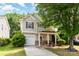 Charming two-story home features a welcoming front porch, attached garage, and well-maintained landscaping at 516 Tribune Dr, Charlotte, NC 28214