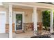 Inviting front porch with stone accents, a decorative wreath, and a cozy seating area at 516 Tribune Dr, Charlotte, NC 28214