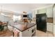 Open floorplan shows a kitchen featuring a black fridge and island, with the living room in the background at 516 Tribune Dr, Charlotte, NC 28214