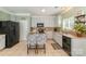 Bright kitchen with tile floors, gray cabinets, island with seating, and modern appliances at 516 Tribune Dr, Charlotte, NC 28214