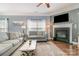 Inviting living room features a fireplace, a ceiling fan, large windows, and hardwood flooring at 516 Tribune Dr, Charlotte, NC 28214