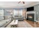 Inviting living room features a fireplace, a ceiling fan, large windows, and hardwood flooring at 516 Tribune Dr, Charlotte, NC 28214