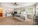 Spacious main bedroom with three windows, carpet, a dresser with decorations, and a home office setup at 516 Tribune Dr, Charlotte, NC 28214