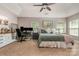 Spacious main bedroom featuring a tray ceiling, three windows, carpet, and a home office setup at 516 Tribune Dr, Charlotte, NC 28214