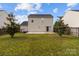 A view of the backyard with a concrete patio and green grass lawn at 5312 Peach Place Ln, Charlotte, NC 28216