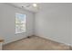 Bright bedroom with a ceiling fan, neutral carpet, and a large window offering ample natural light at 5312 Peach Place Ln, Charlotte, NC 28216