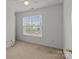 Bright bedroom with neutral carpet and a large window offering ample natural light at 5312 Peach Place Ln, Charlotte, NC 28216