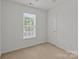 Bright bedroom with neutral carpet and a large window offering ample natural light at 5312 Peach Place Ln, Charlotte, NC 28216
