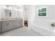 Bright bathroom featuring double vanity, a tub, and separate tiled shower at 5615 American Way, Denver, NC 28037