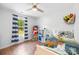 Bright bedroom featuring hardwood floors, a ceiling fan and a window with blue striped curtains at 5615 American Way, Denver, NC 28037
