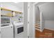 Well-equipped laundry room with wooden shelves and access to the stairs at 5615 American Way, Denver, NC 28037