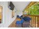 Relaxing screened-in porch with comfortable seating, a TV, and views of the surrounding greenery at 5615 American Way, Denver, NC 28037