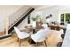 Cozy dining area featuring hardwood floors, a round table, and stylish chairs, adjacent to a modern staircase and the living room at 6501 Piney Path Rd, Charlotte, NC 28212