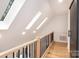 Bright upper hallway featuring hardwood floors, skylights, and a sliding barn door for a modern and airy feel at 6501 Piney Path Rd, Charlotte, NC 28212