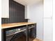 Laundry room with modern appliances, sleek cabinetry, and butcher block countertop at 6501 Piney Path Rd, Charlotte, NC 28212