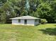 Exterior view of a single-story outbuilding surrounded by a grassy yard and trees at 675 E Ritchie Rd, Salisbury, NC 28146