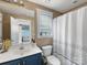 Bathroom featuring blue vanity with a white sink, toilet and shower with curtain at 6909 Dunton St, Huntersville, NC 28078