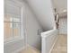 Bright hallway with a staircase, window, and neutral tones, creating a welcoming transition between levels of the home at 6909 Dunton St, Huntersville, NC 28078