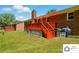 Backyard with a red brick house and a red deck with stairs leading down to the yard at 707 Hester Dr, Dallas, NC 28034